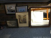 All items including four framed pictures and one mirror arranged on the ground showing relative sizes and frames