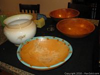 Porcelain jardiner and three wooden bowls arranged on a countertop, showing overall condition and design details.