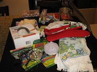 Full view of assorted tea towels, oven mitts, kitchen gadgets, and other kitchen accessories displayed on a countertop.
