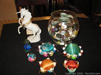 Full lot with all items including pin cushions, jar of buttons, ceramic horse, and decorative glass eggs on a dark surface
