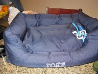 Navy blue Rogz fabric dog bed on a table, showing padded sides and cushion with Rogz logo.