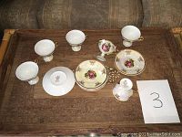 Full set of 6 mini porcelain teacups and 6 saucers arranged on a wooden surface.