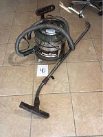 Filter Queen vacuum cleaner with hose and floor nozzle placed on tiled floor with a number card 40