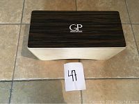 Top view of the wooden bongo box showing the dark wood finish striking surface with the GP Granite Percussion logo.