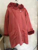 Front view of reddish-brown wool winter coat with outer silky layer and faux fur trimmed cuffs and hood edge.