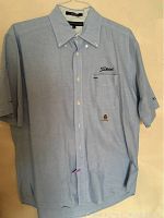 Full front view of light blue Titleist shirt made by Tommy Hilfiger showing the fit, collar, chest pocket, and logos.