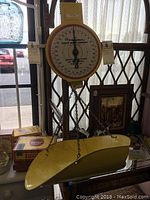 Full view of the vintage American Family Scale with yellow tray, mounted in front of a window and surrounded by other vintage items.