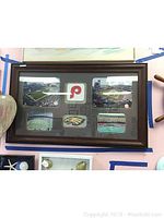 Framed collage including six photos of Philadelphia Phillies baseball stadiums and a central logo cut-out for the Phillies and Eagles.