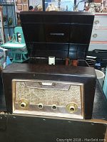 Full view of the vintage Admiral radio phonograph combo with the lid open showing the base and front grille with controls