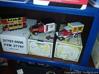 Three Coca Cola collectible vehicles set on original branded boxes.