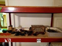 Shelf with multiple pairs of sunglasses, wooden box, and other empty boxes.