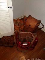Five leather totes and purses in a corner showing various shades of brown and one red patterned tote
