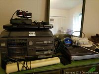 Full view of stereo system, DVD player, various cables, and turntable on a green surface