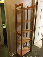 Full view of the tall wooden bookshelf showing five shelves and overall structure.