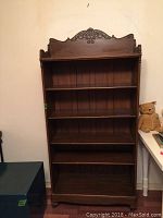 Front view of the dark wooden bookshelf showing full height and all shelves with overall condition.