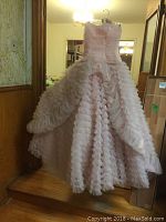 Full front view of the pink strapless party dress with multiple layers of ruffled tulle forming a full skirt.
