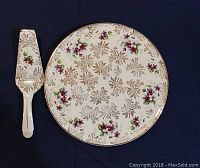 Full view of the Aynsley 11 inch chintz cake plate and matching server on a dark background.