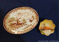 Overview of the oval windmill platter with scenic design and smaller Noritake hand painted dish beside it