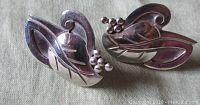 Top view showing the detailed leaf design with berry clusters and polished silver finish.