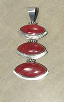 Front view of pendant showing three oval sponge coral cabochons set in sterling silver, aligned vertically with hinges.