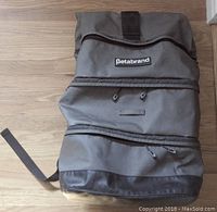 Front view of grey backpack showing three zippered compartments and Velcro closure, Betabrand logo visible on front.