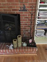 Full lot showing all items including mitten rack, candles, candle holders, nutcracker, and ceramic oil lamp on a brick hearth next to fireplace