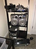 Shelf unit with stereo system, speakers, and various electronic components including a Marantz CD player and other devices