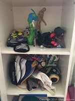 Shelf storage showing various men's ball caps, soccer balls, sunglasses, yoga mats, and a wooden mannequin.
