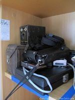 Three vintage box and twin-lens reflex cameras with cases on shelf