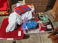 Photo of assorted Christmas holiday items including ornaments, fabric gift bags, glass reindeer swizzle sticks, and boxes.