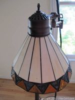 Close-up of the faux Tiffany style lamp shade showing cream colored glass with black and amber triangular accents.