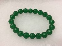 Full view of the bracelet showing all 20 polished green jade beads arranged in a circle.