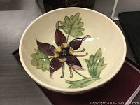 Top view of bowl showing inside hand-painted Columbine flower and green leaves.