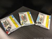 Three unopened packs of 1989 Fleer Baseball cards shown with backs facing upward, displaying bar codes and product information.