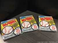 Three unopened sealed 1989 Fleer Baseball cards packs with front package design showing baseball graphic and brand logo.