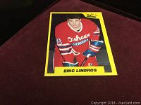 Front of Eric Lindros rookie hockey card with Oshawa Generals red jersey, yellow border and player name.