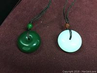Close-up photo showing green and white jade necklaces with cords and beads