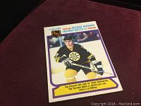 Front of the 1980 O-Pee-Chee Ray Bourque Rookie Record Breaker hockey card showing player image and text highlights.