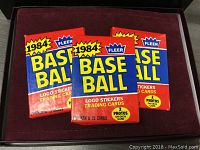 Three sealed 1984 Fleer Baseball card packs showing front with colorful label and pack details.