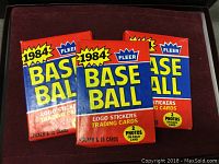 Pack front view showing the three unopened 1984 Fleer Baseball packs with colorful packaging.