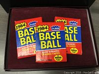 Three sealed 1984 Fleer Baseball trading card packs in red and blue packaging with yellow '1984' bubble on front.