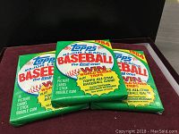 Three unopened 1984 Topps Major League Baseball card wax packs with brand and pack details visible.