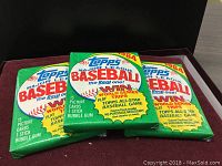 Three unopened packs of 1984 Topps Major League Baseball cards front view, showing green packaging with Topps branding and baseball logo.