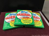 Three unopened 1984 Topps Major League Baseball card packs displayed together, showing front and top of packaging with branding and contest information.