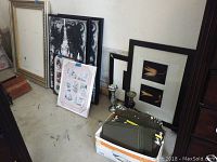 Various sizes of wall frames and multiple candle holders displayed together on floor, showing condition including chips and tarnish.