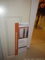 White 2 panel smooth closet bifold door in original packaging with Masonite label visible specifying this item.