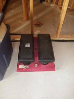 Wide angle view of the SLM Stair Climber Plus stepper showing red base and black pedals on basement floor.