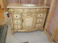 Front view of bathroom vanity cabinet showing six drawers, center cabinet door, carved scrollwork and decorative cabriole legs
