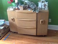 Front view of Heywood Wakefield cabinet with three central drawers and two side cabinets.