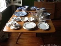 Full view of rectangular blonde wood dining table with dishes on top